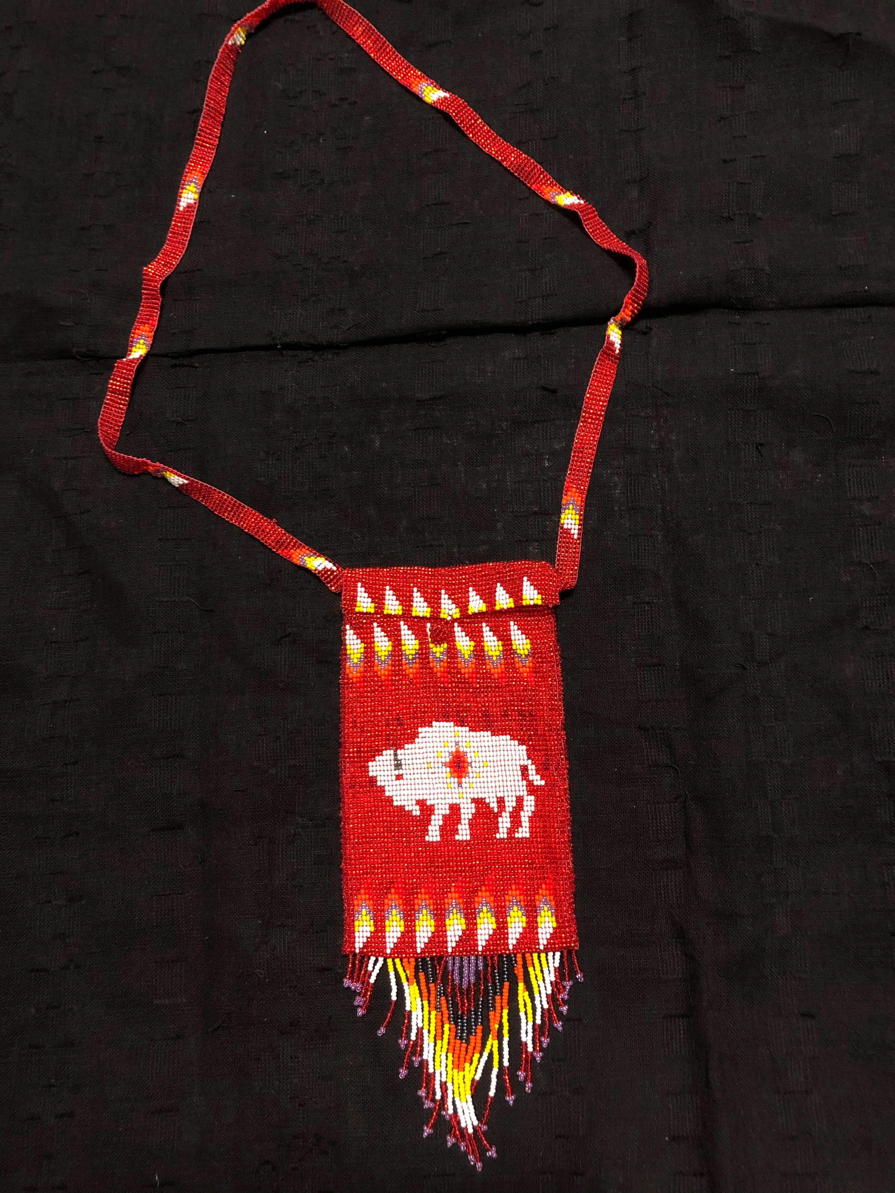 Guatemalan handcrafted glass bead shoulder bag, approximately 4” x 7” with a 32 inch strap.  The bags are decorated on both side