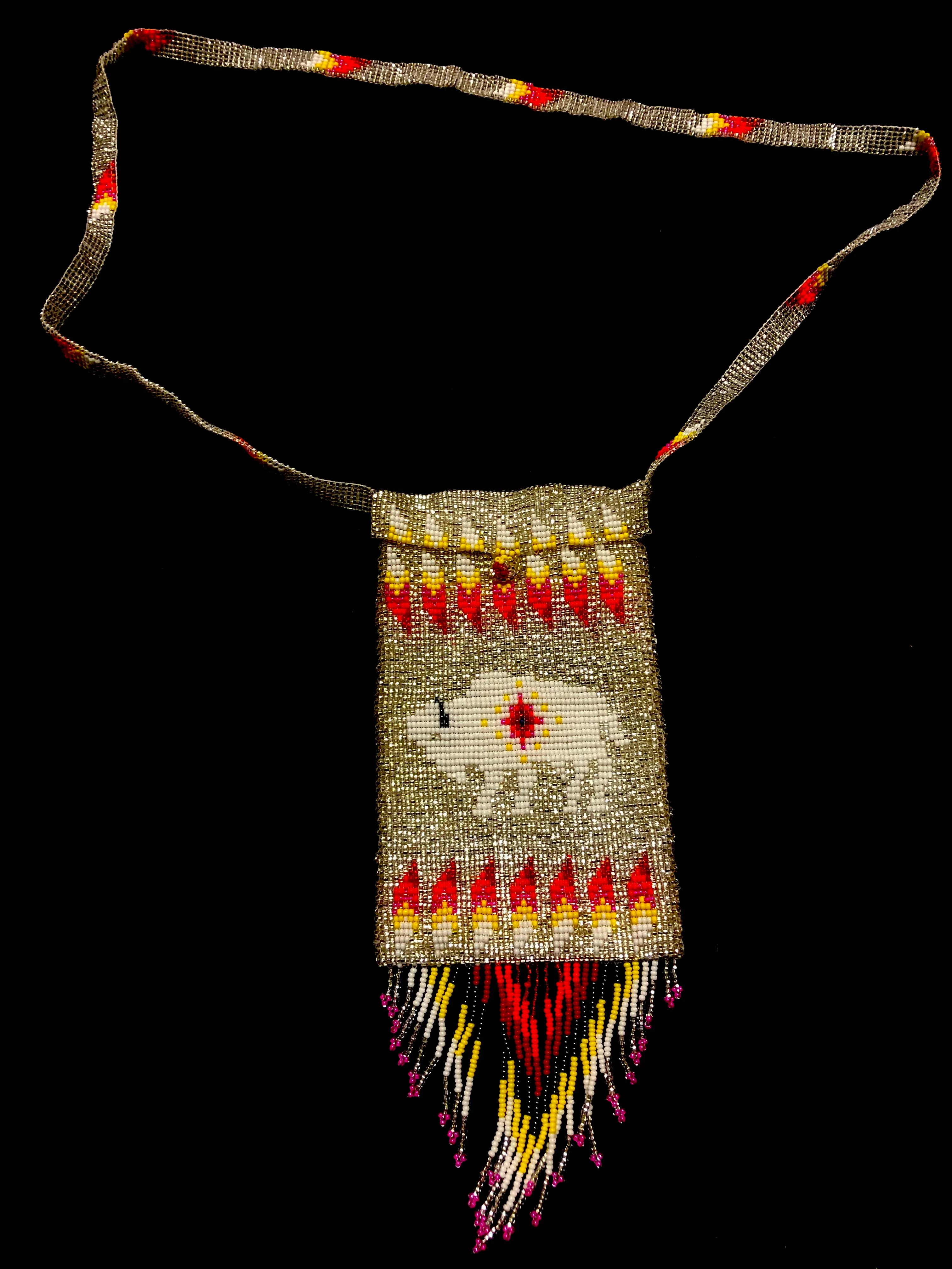 Guatemalan handcrafted glass bead shoulder bag, approximately 4” x 7” with a 32 inch strap.  The bags are decorated on both side